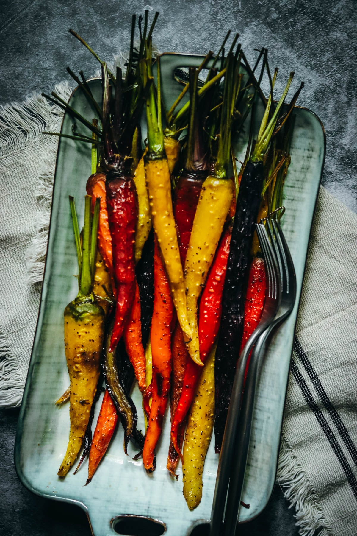 Dish of roasted carrots on a napkin.