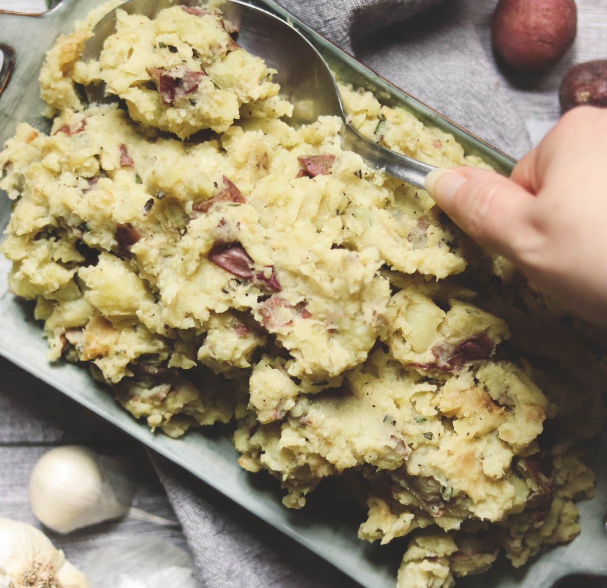 Dish of mashed potatoes on a gray background.