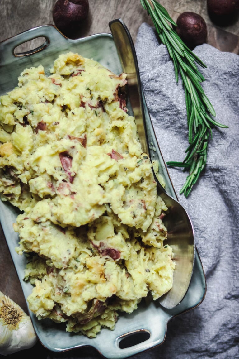 Red skinned mashed potatoes in an oblong dish.
