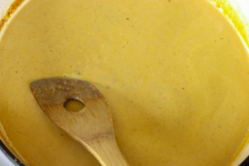 Artichoke cream sauce being stirred.
