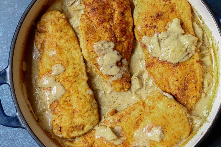 Smothered Chicken in a cast iron pan.