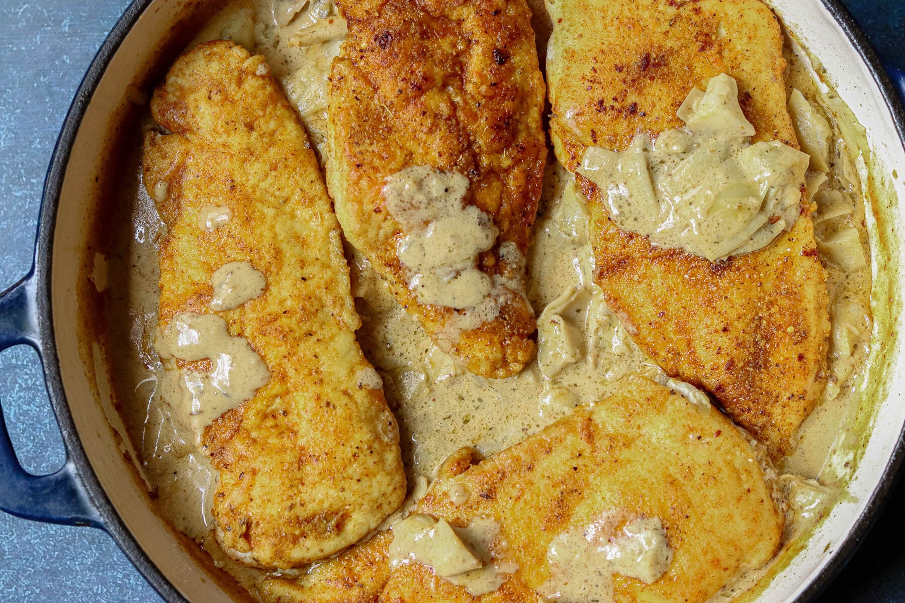 Smothered Chicken in a cast iron pan.