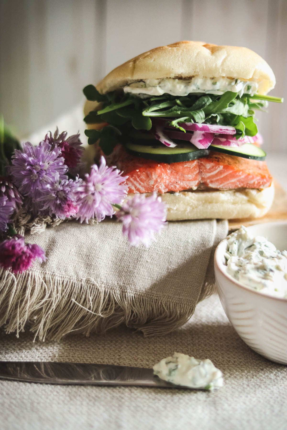 Salmon sandwich with a bowl of cream cheese spread.