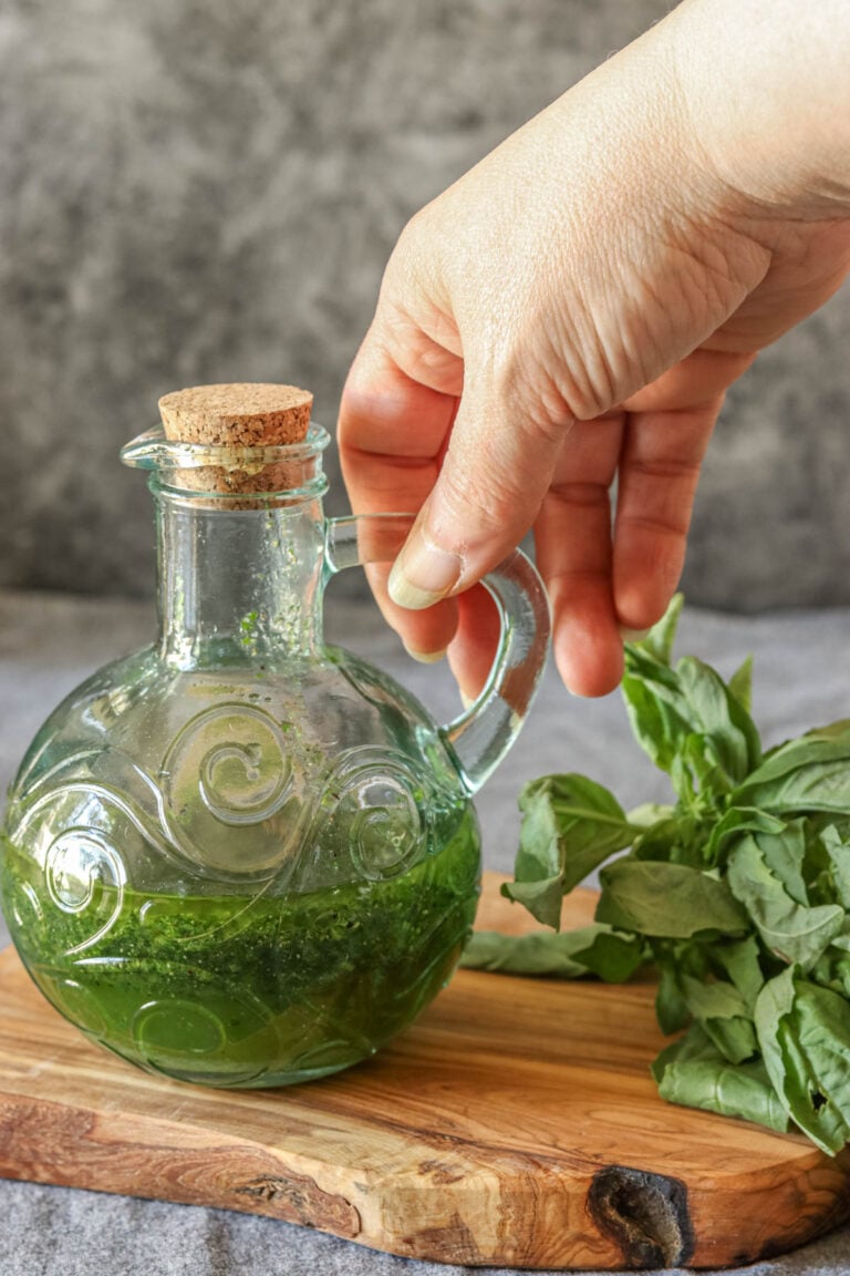 Bottle of basil vinaigrette being picked up by the handle.