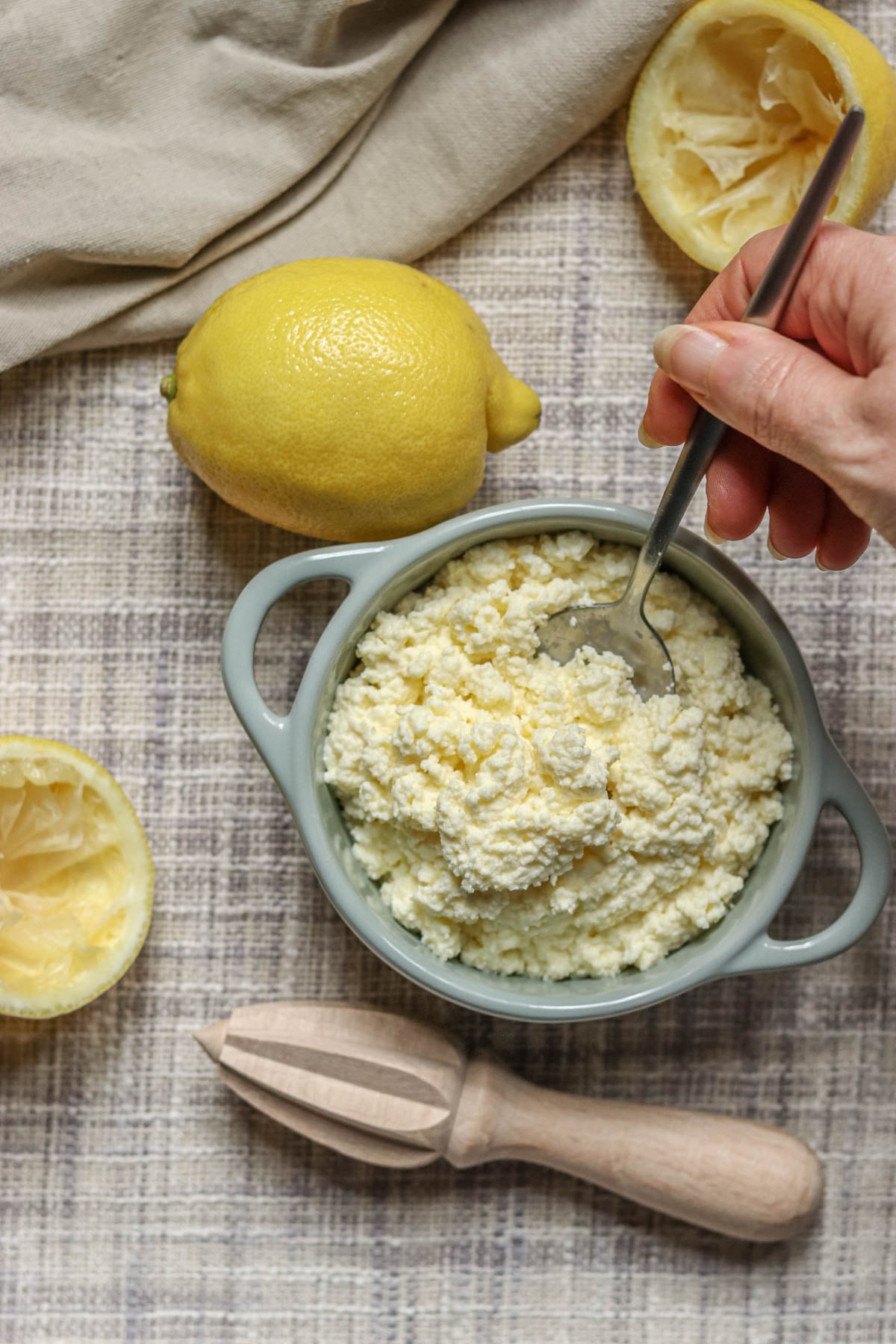 Ricotta cheese being spooned out of a bowl.