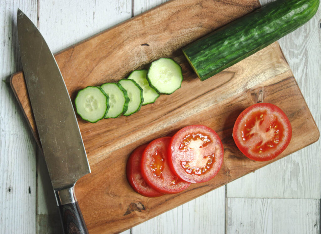 Photo of tomato and cucumber being cut.
