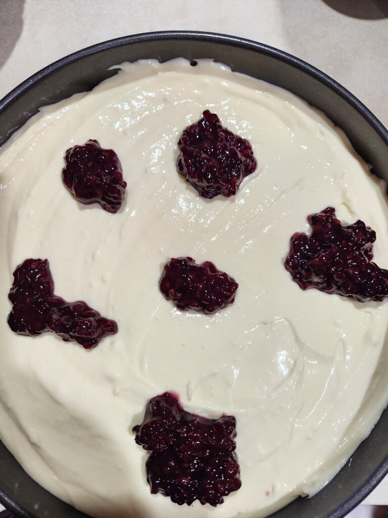 Blackberry sauce spooned onto the top of the cheesecake.