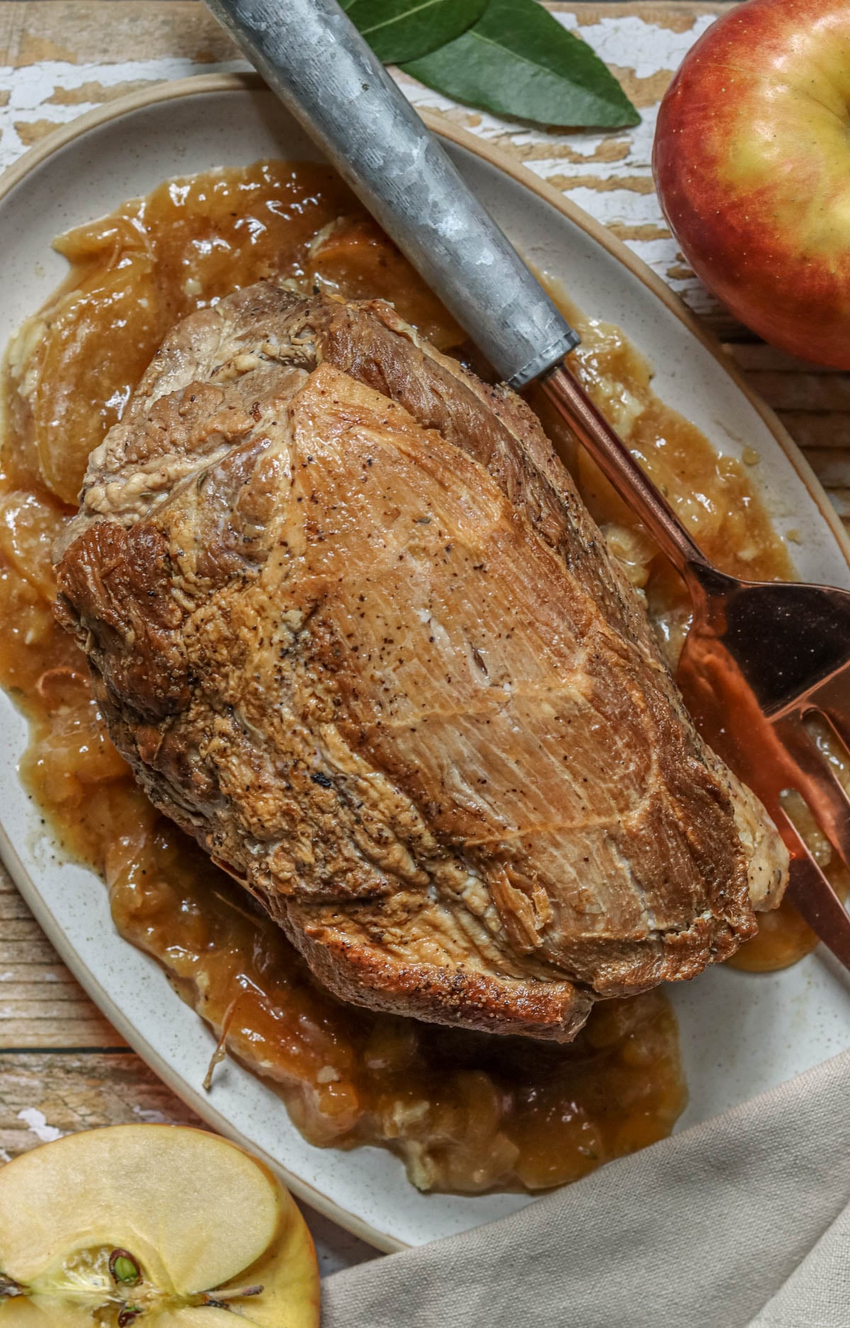 Cider braised pork roast on a platter with a fork.
