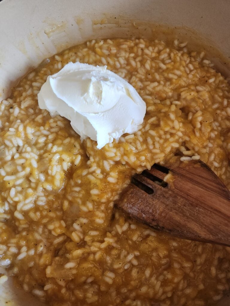 Adding mascarpone to risotto.