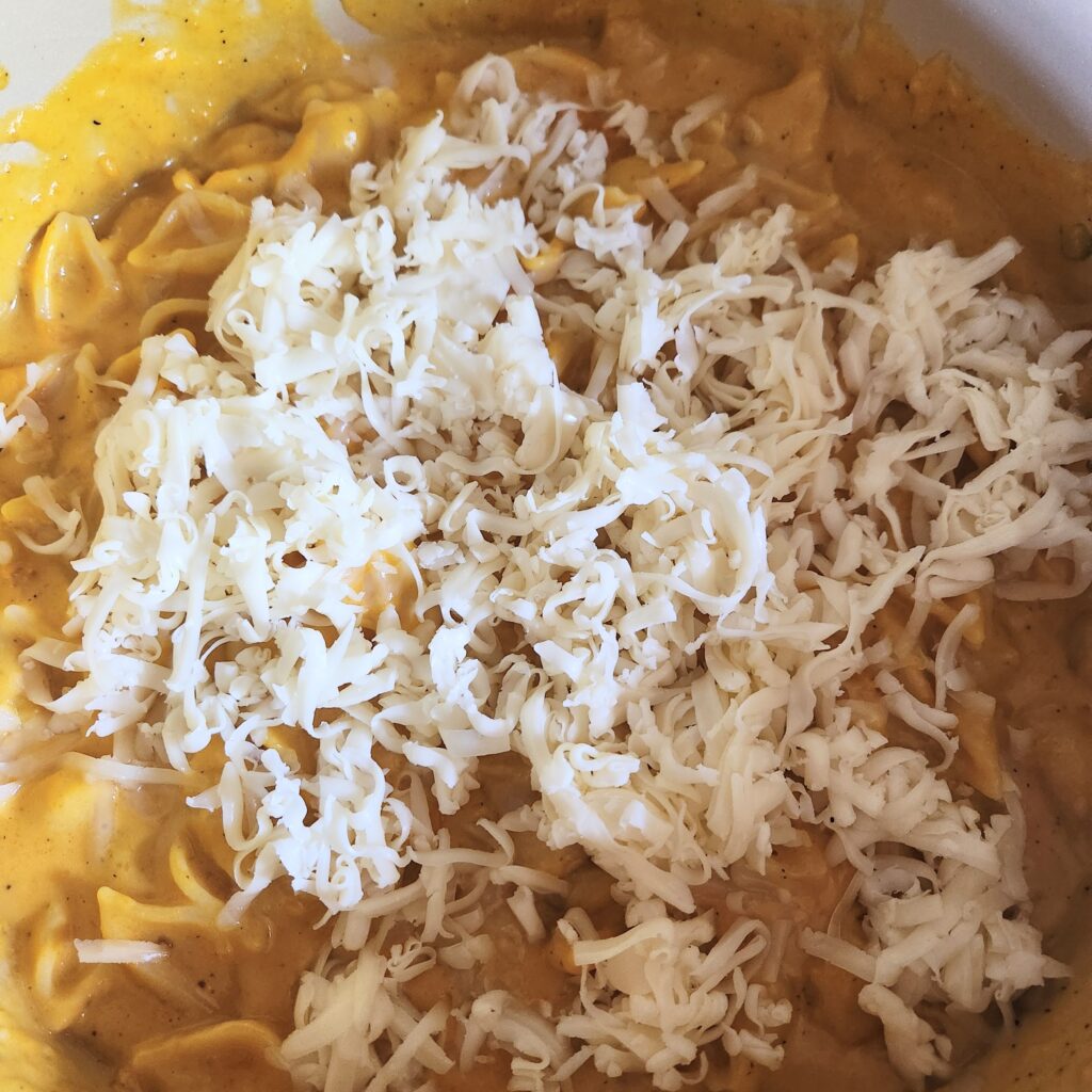 Adding cheese on top of macaroni.
