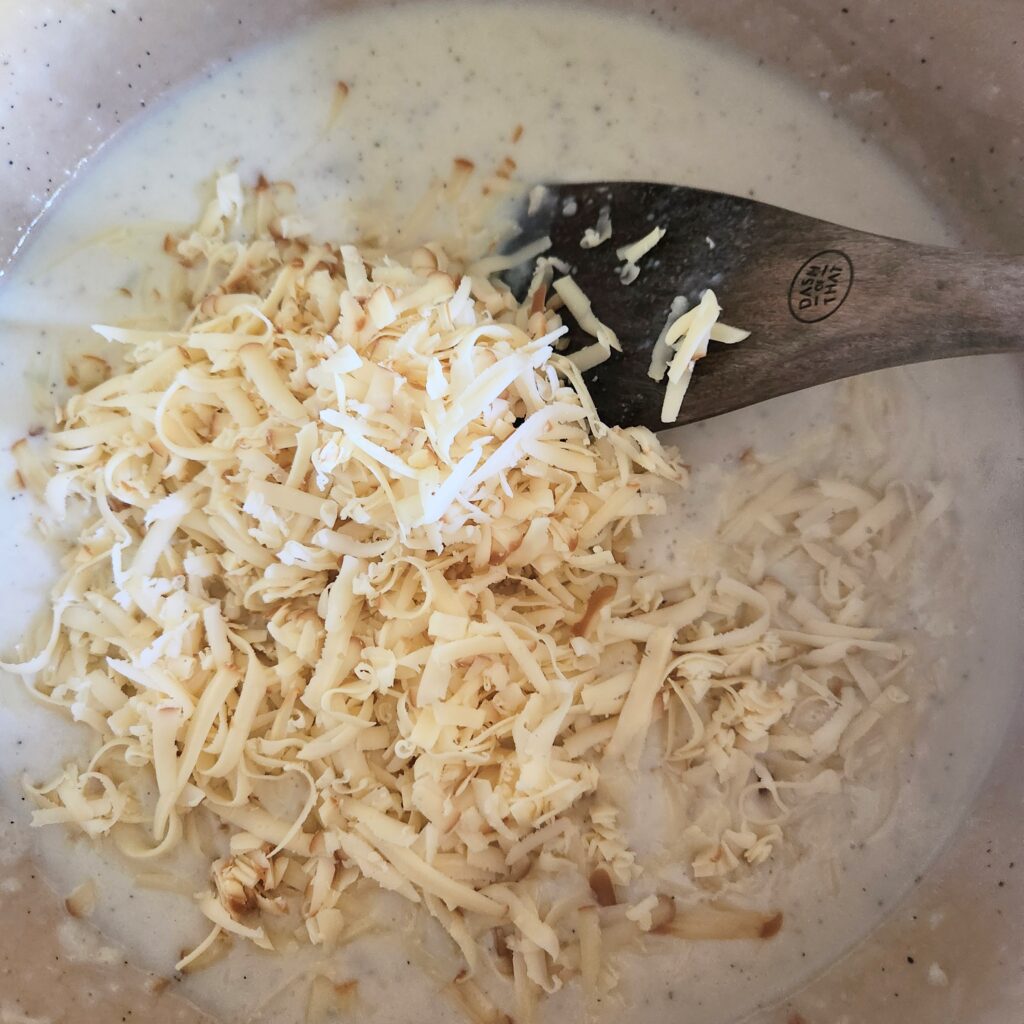 Adding cheese to the sauce.