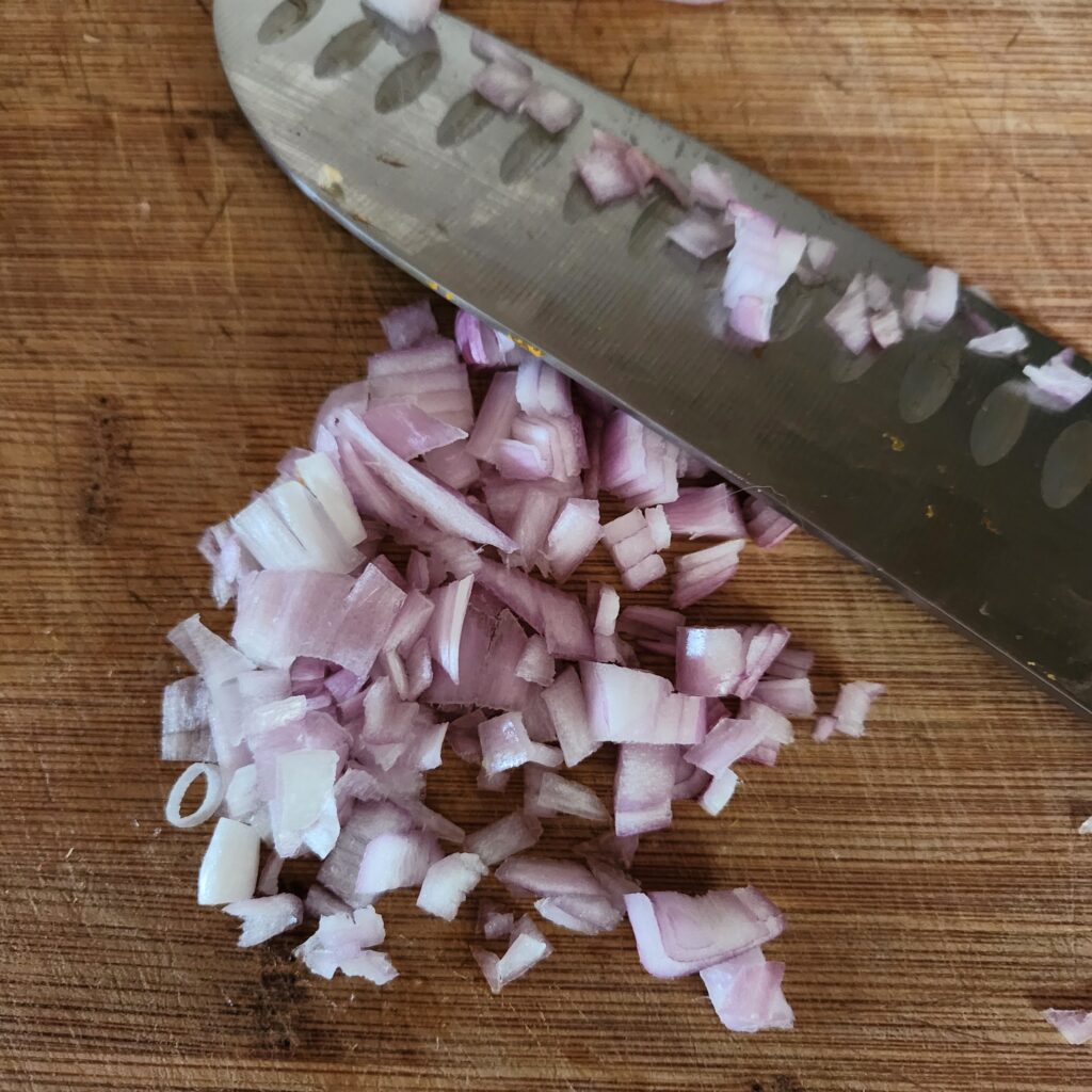 Chopped shallots on a cutting board.