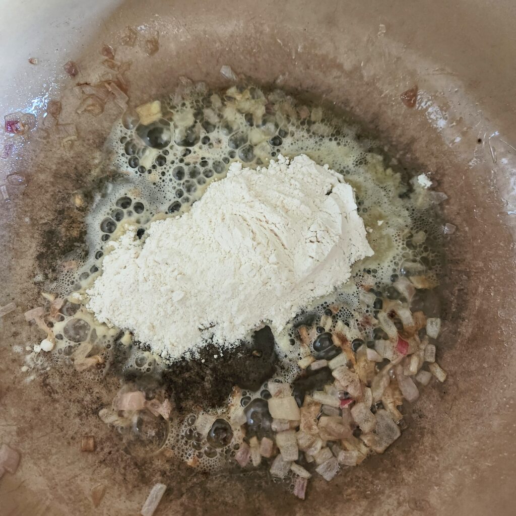 Adding flour to make the roux.
