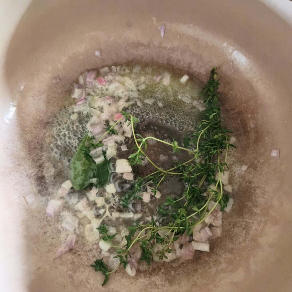 Cooking herbs and shallots with butter.