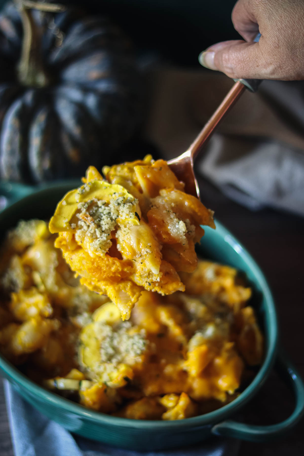 Spoonful of mac and cheese over a casserole dish.