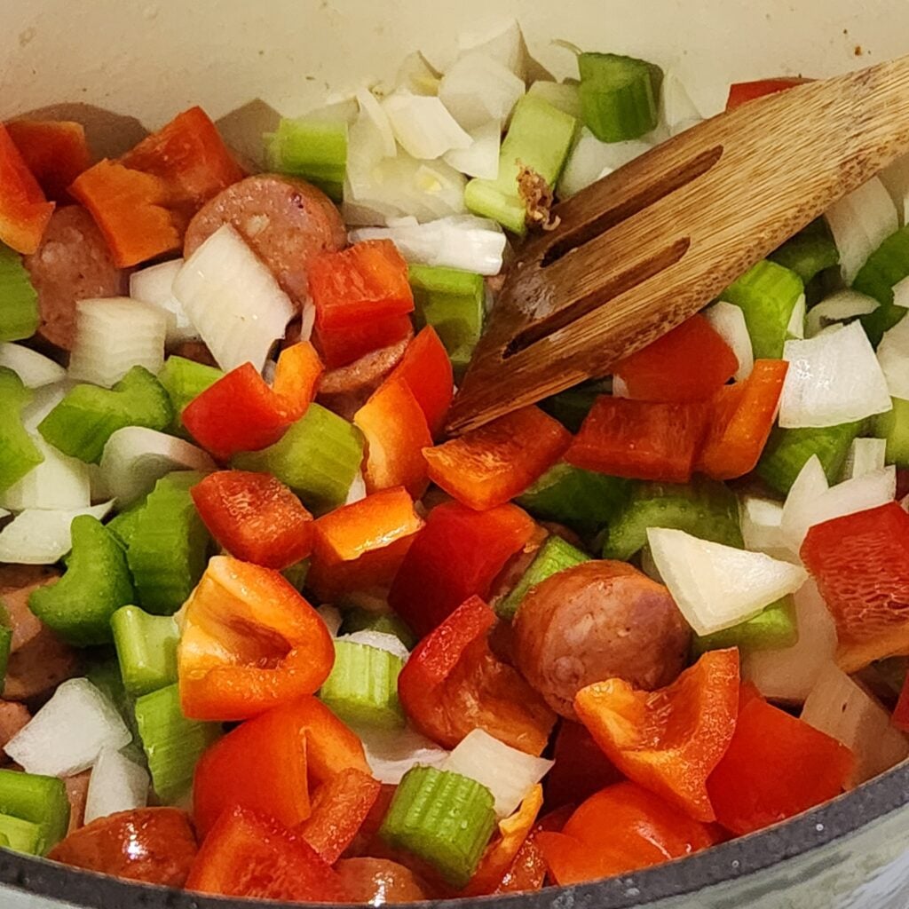 Adding the vegetables to the pot.