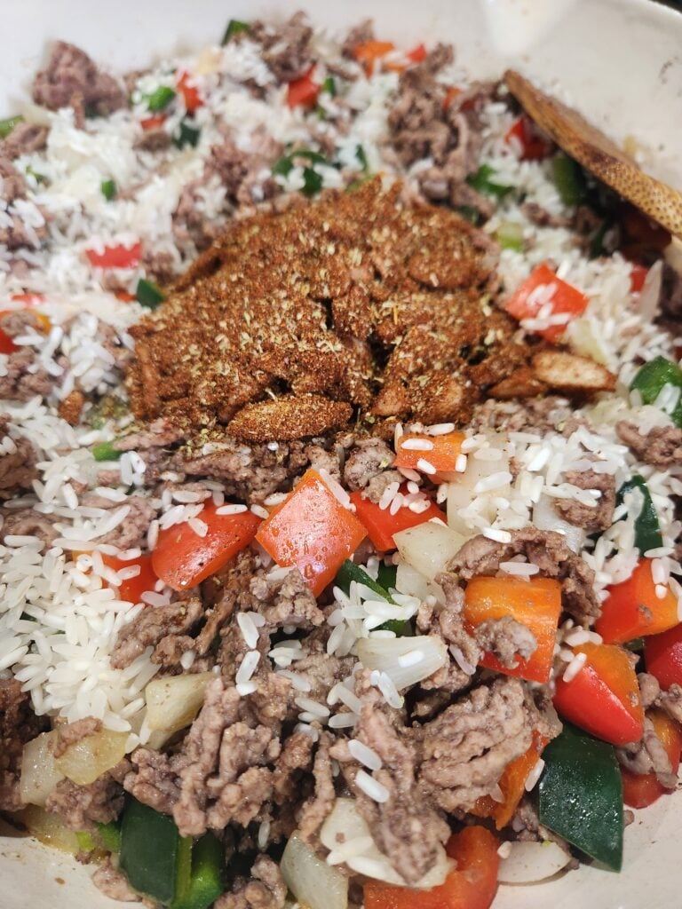 Adding the rice and the seasonings.
