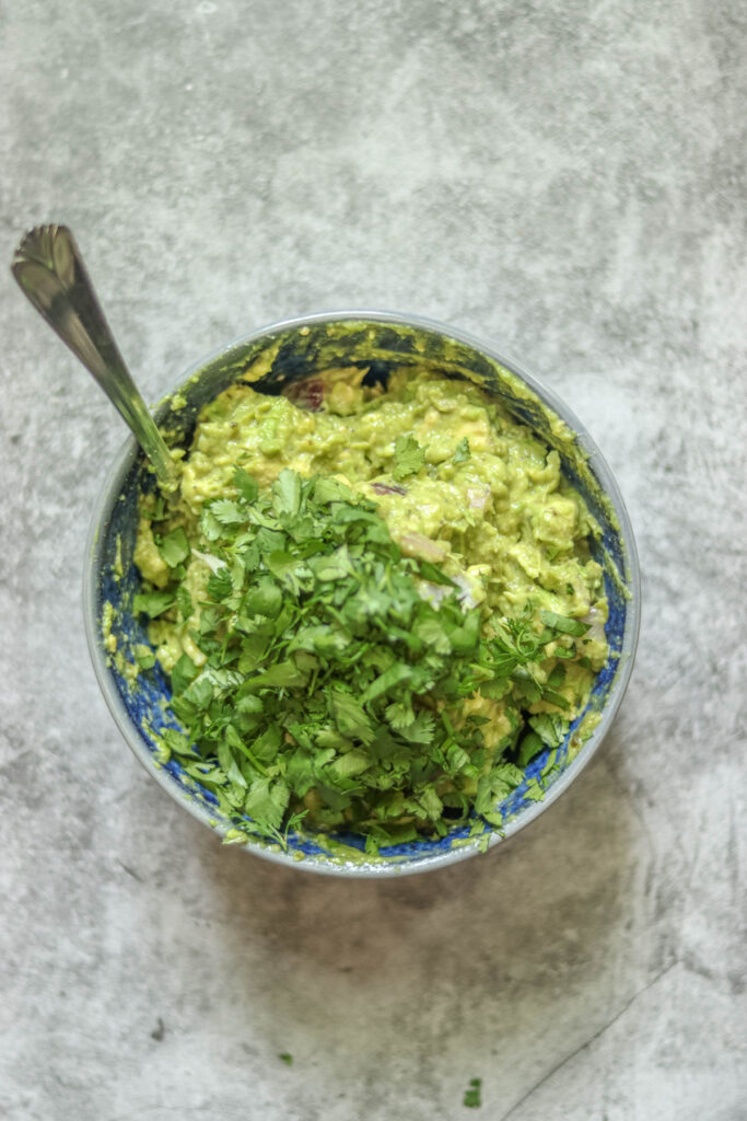 Adding cilantro to the guacamole.