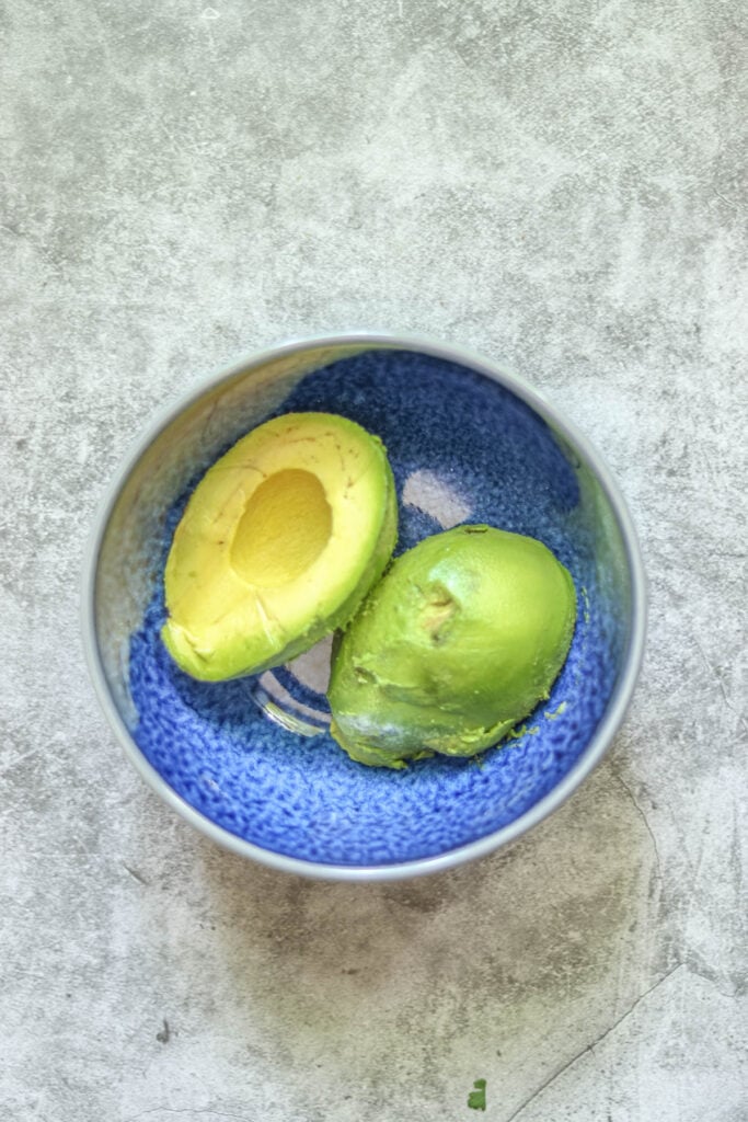 Avocado halves in a bowl.