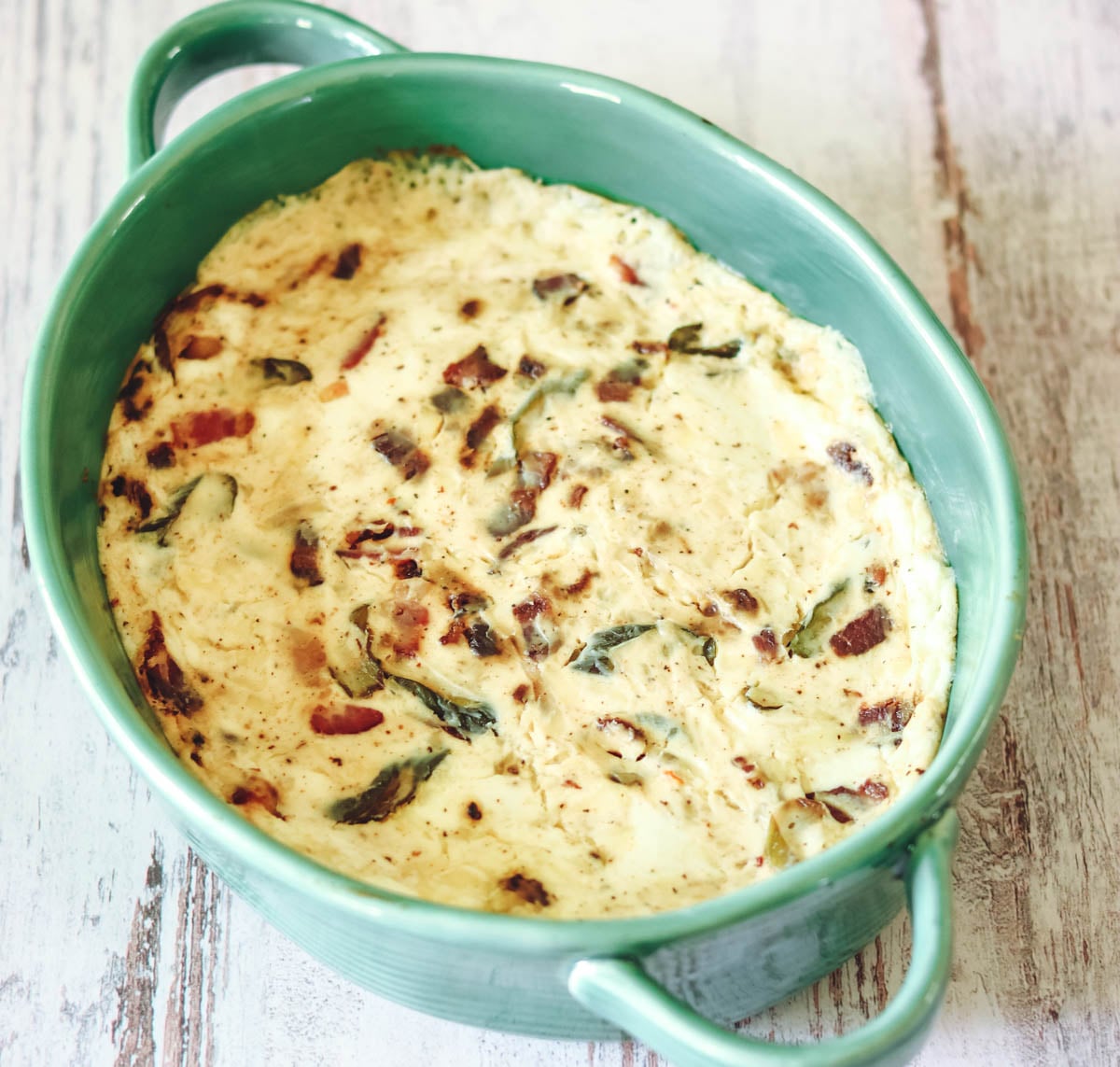 Bacon and cheese dip in a green baking dish.