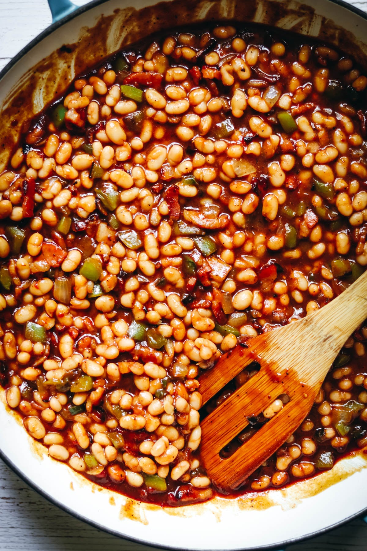 Homemade baked beans in a large cast iron pan.